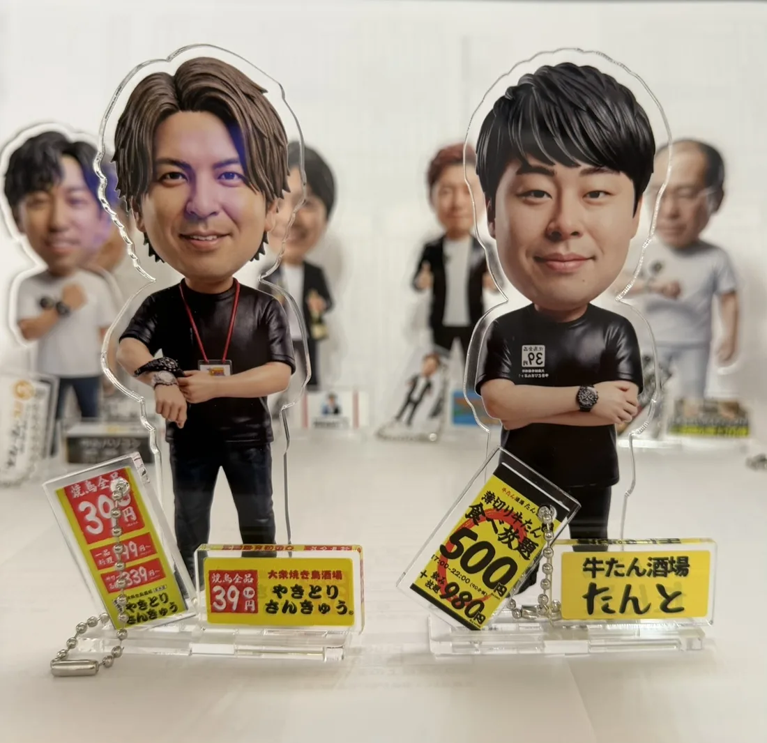 お店のロゴやメニューをネーム板とキーホルダーに入れた、2体の人物アクリルスタンドの作成例